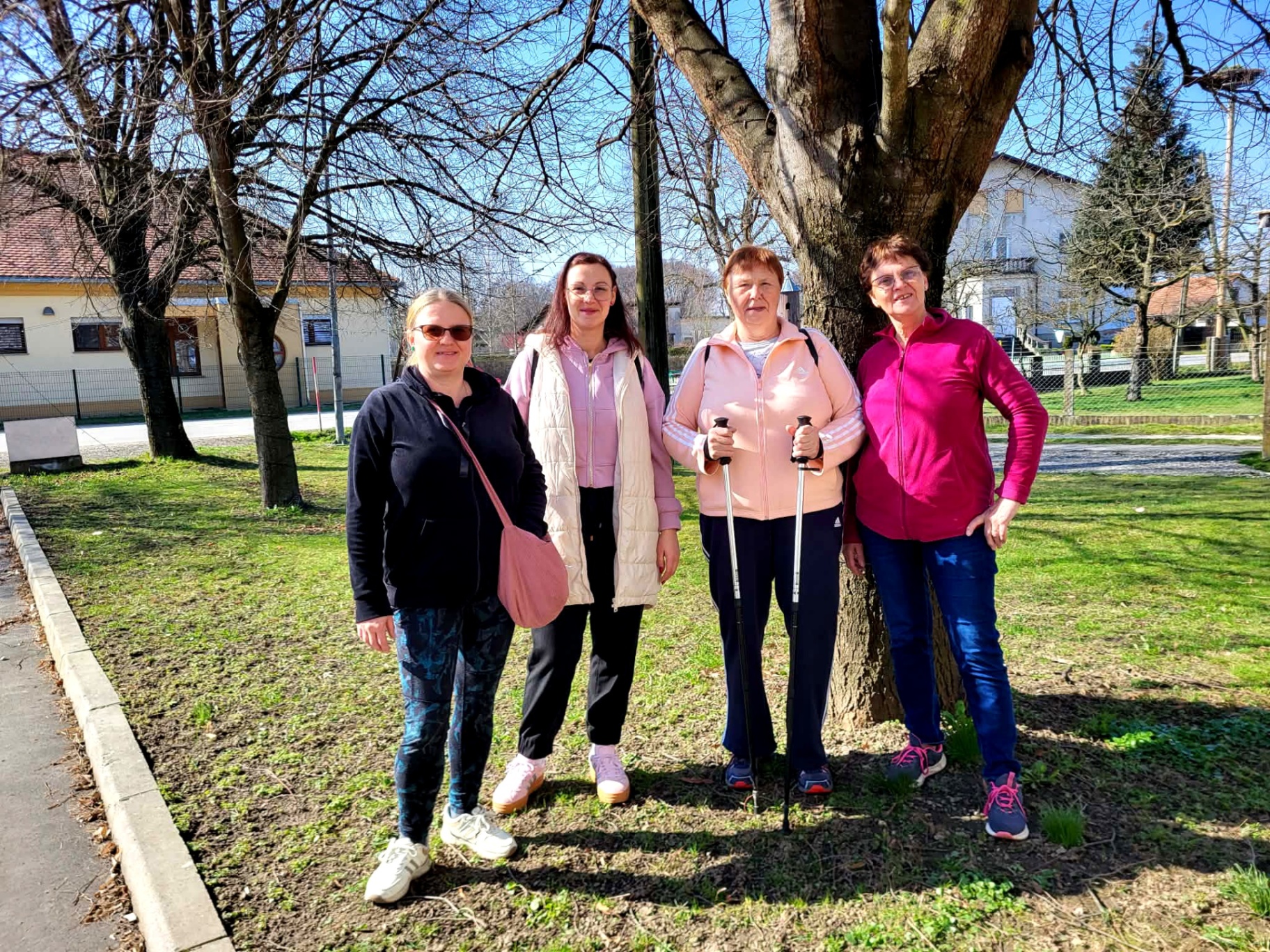 Skupina pohodnic pod pomladnim drevesom v parku