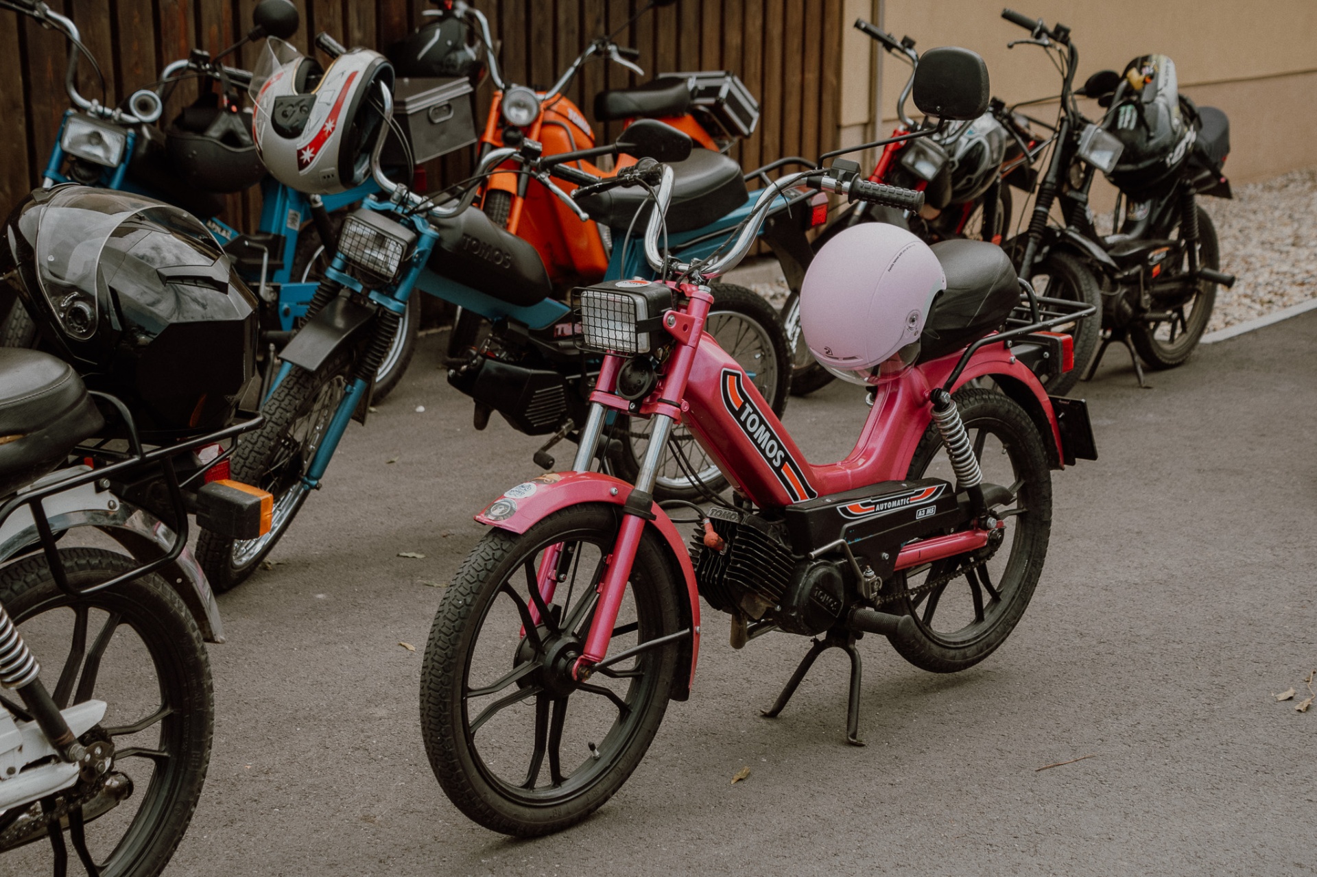 Rožnati Tomos Automatic med drugimi mopedi na postanku