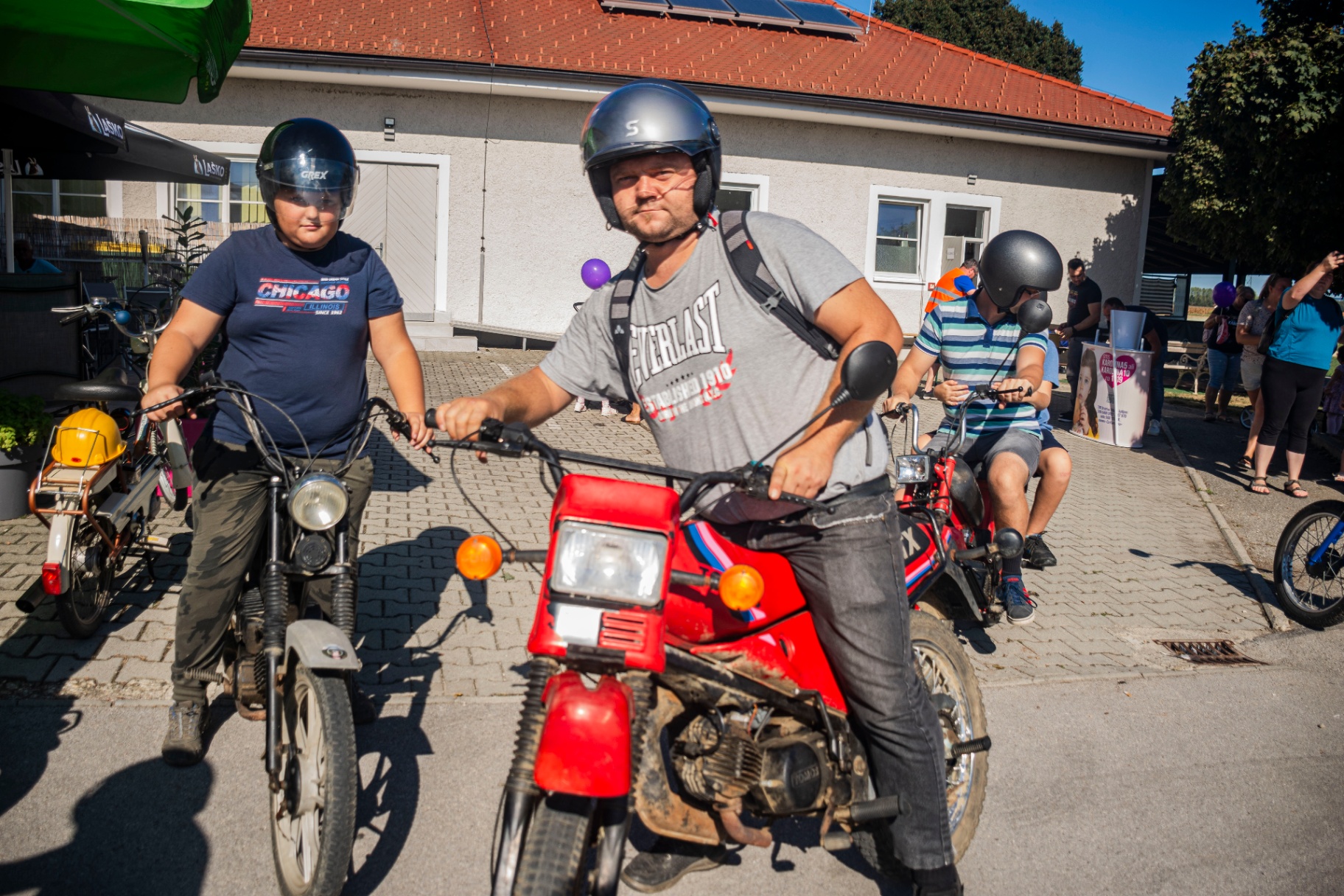 Oče in otrok skupaj na rdečem Tomosu