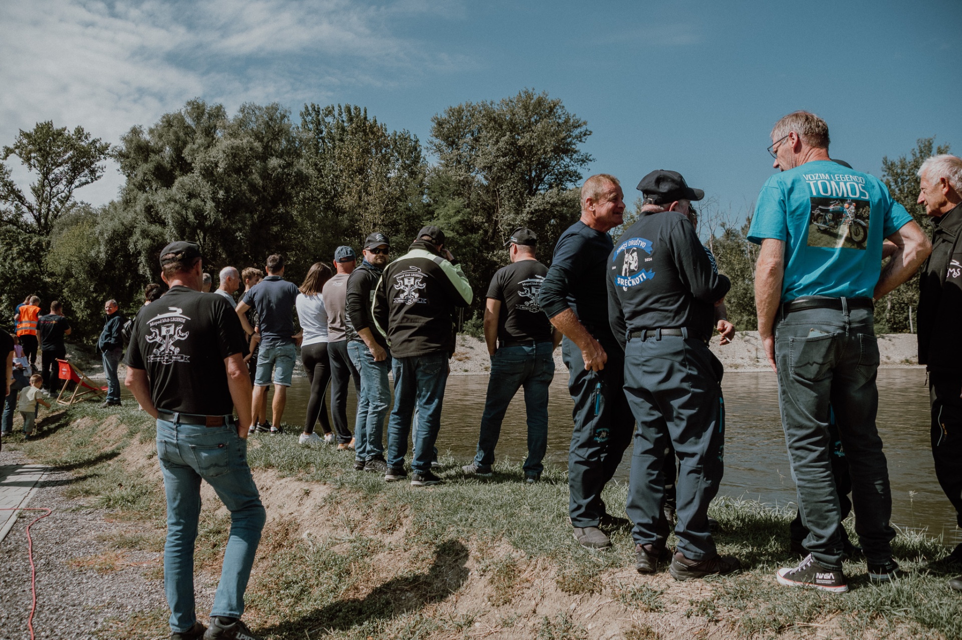 Skupina udeležencev ob reki Muri med postankom na soncu
