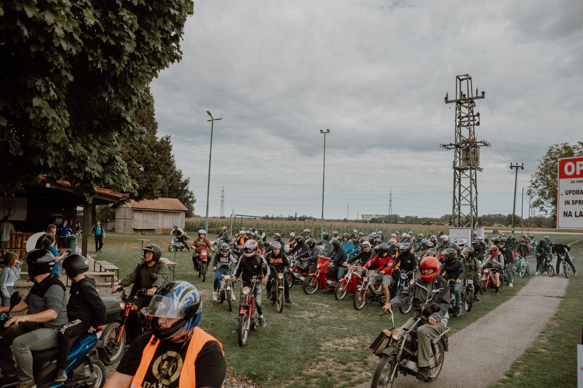Velika skupina udeležencev na mopedih pri pripravi na vožnjo, MOPED Mur 2025