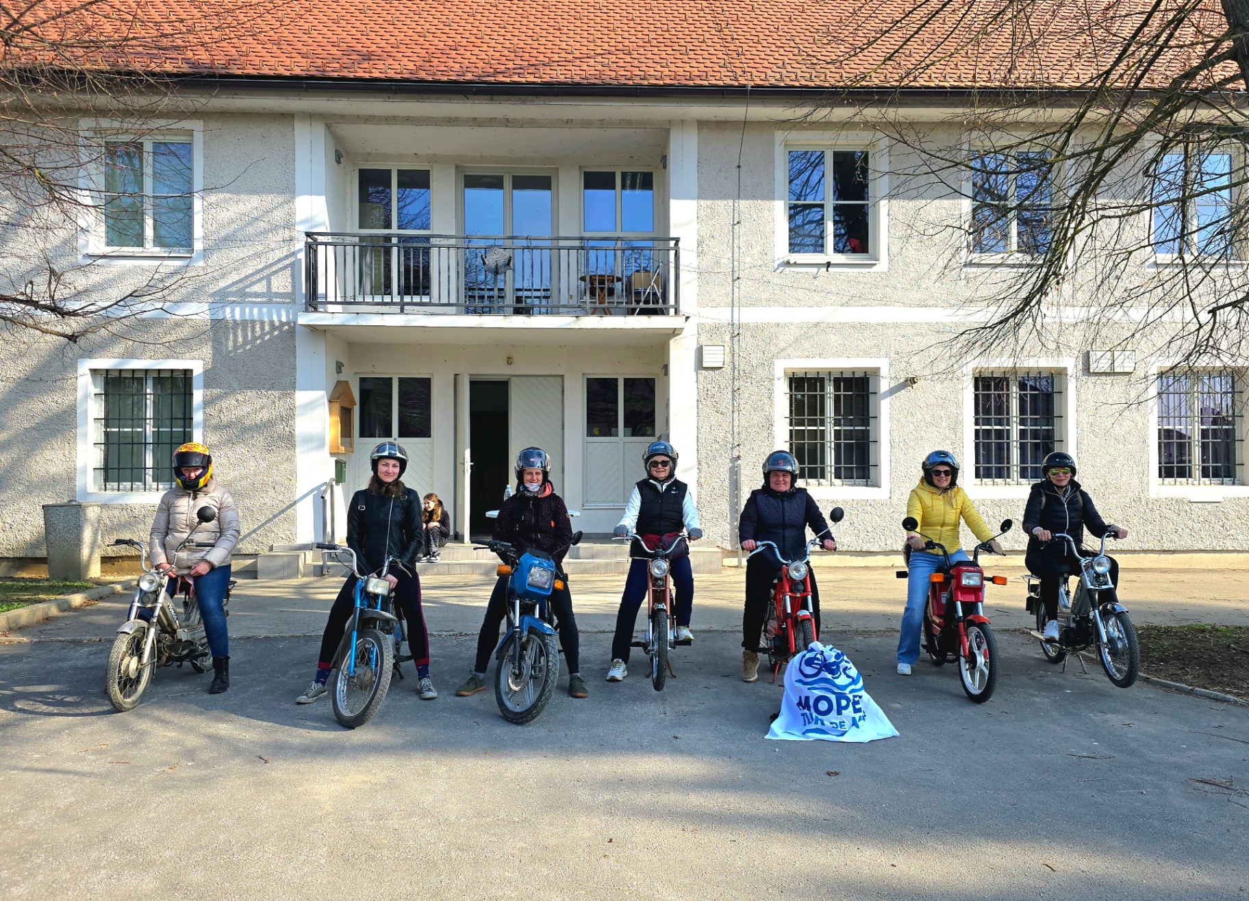Skupinska fotografija udeleženk 8. marec na mopedih pred Zadružnim domom Cven