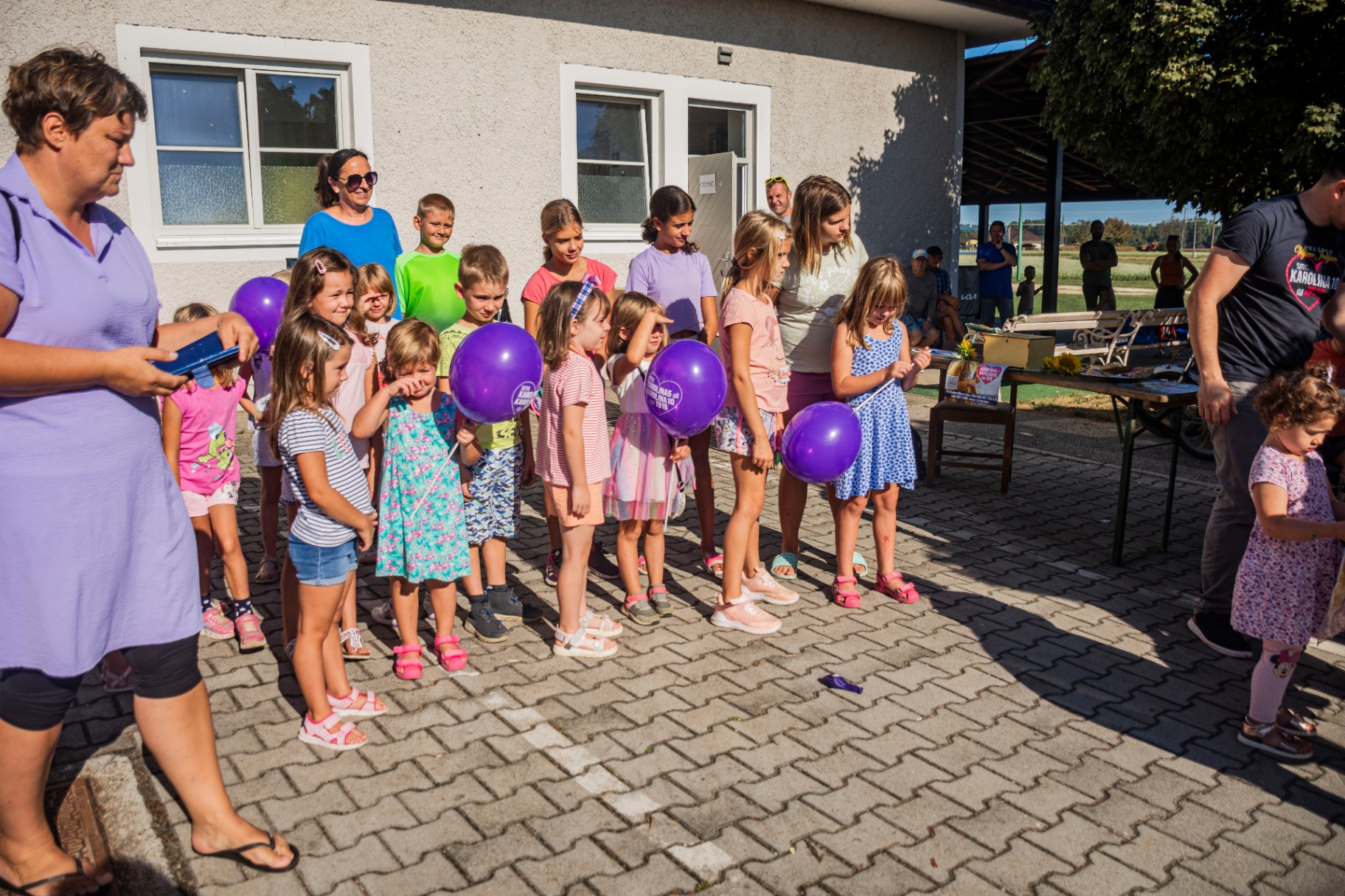 Otroci s podpisano listino in vijoličnimi baloni
